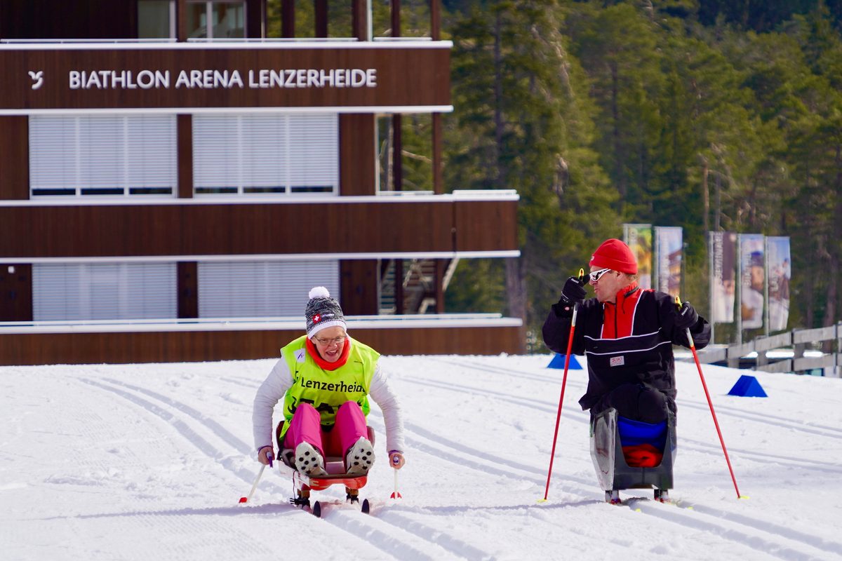 Sportlerinnen und Sportler im Sitzski vor der Biathlon Arena Lenzerheide